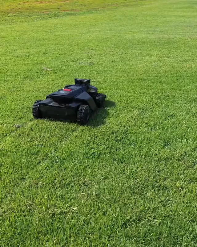 A robotic mower cutting a green lawn